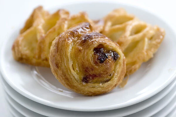 Small danish pastries on stack of white plates credit: Marie-Louise Avery  /  thePictureKitchen