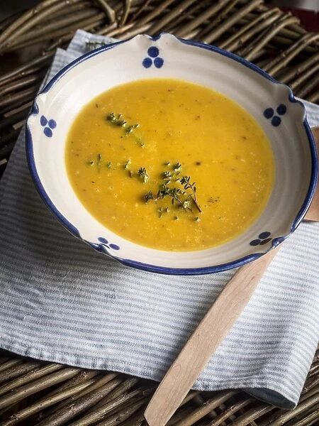 Soup of squash roasted with garlic and thyme, served in blue and white bowl with