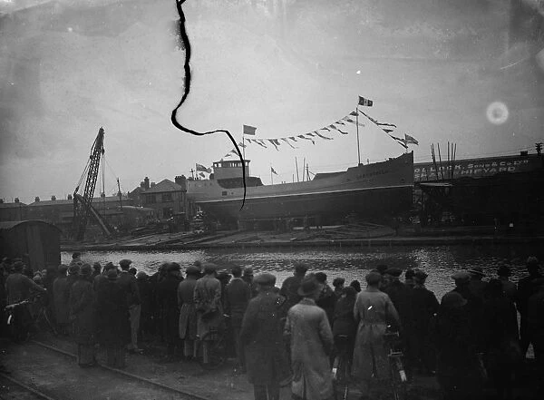 Spectators wait to see the new ship launch as the ship sits broadside on the slipway