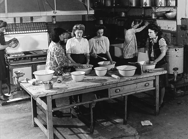 Teaching young women cooking in a kitchen 1950s