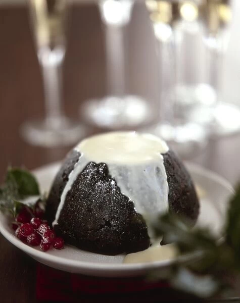 Traditional British Christmas pudding with thin cream or custard poured over