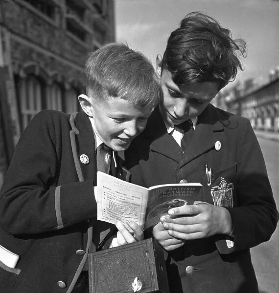 Trainspotters Club Outing. Two young trainspotters consult the British Railways