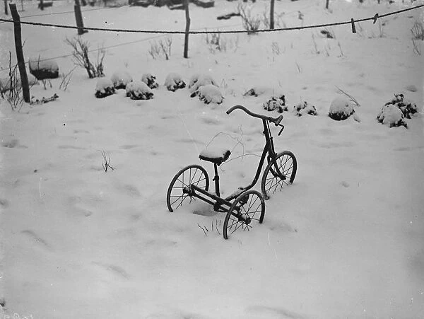A tricycle in the snow, at the site of a fire tragedy in Bromely, Kent