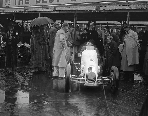 Umbrella as hood at rain sodden Brooklands. Heavy rain caused disappointment to