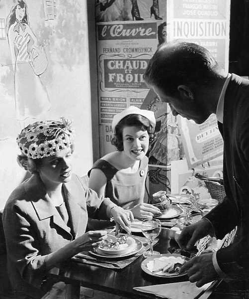 A waiter serves two ladies at lunch in Le P tit Monmartre, Marylebone Lane, London