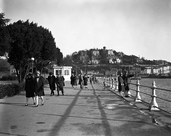 Walking along The Promenade, Torquay, Devon. 1 February 1928