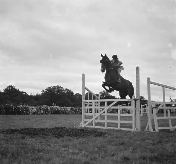 Westerham Hill Horse Show, Kent. A rider and his horse make a jump