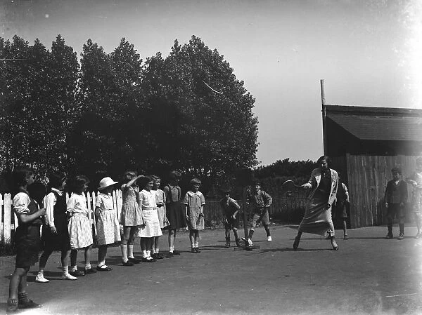 A woman playing stoolball with children in Hartley, Kent. 1937