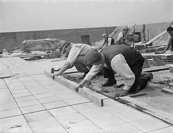 Workers from Val De Travers Asphalt Limited, a paving company, working on a roof in Greenwich