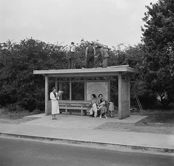 Workes on top of a bus shelter in Chislehurst, Kent. 1936