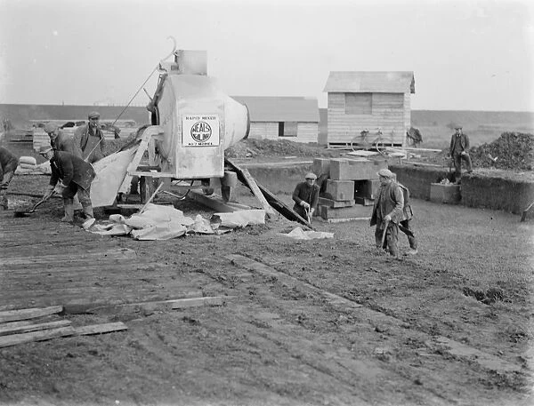 Workmen using a concrete mixer on the construction of the Dartford Tunnel in Kent