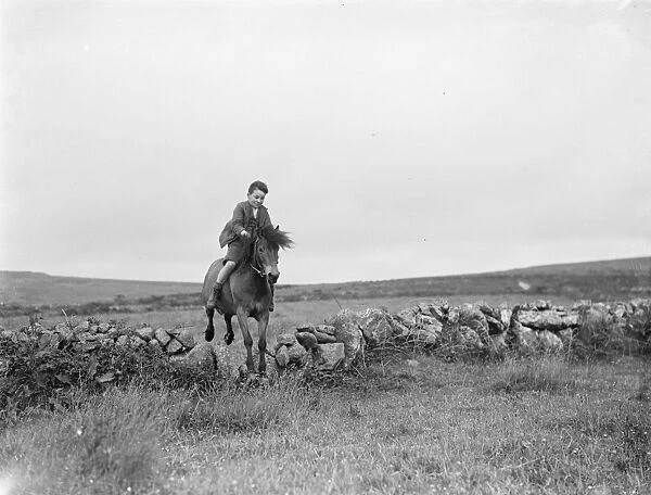 A young boy rides a horse bareback. 1936