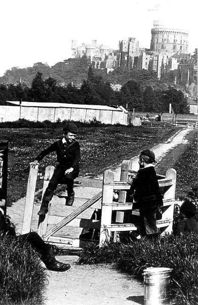 Four young boys playing games by the kissing gate with Windsor Castle in the background