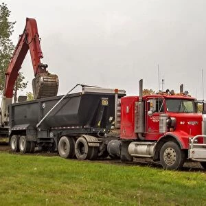 A 6x4 red Kenworth atic unit with a twin axle tipping trailer being loaded at Sudbury
