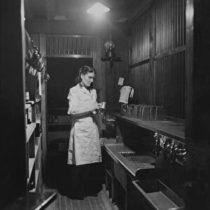 A barmaid cleaning a beer tankard in the Globe Tavern. A state owned pub in Longtown