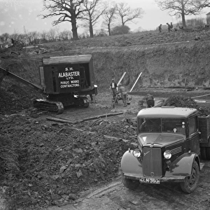 A Bedford truck, full of soil, pulls out of the site where the new swimming pool