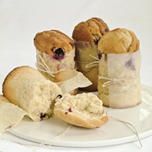 Blueberry muffins made in talll paper cases of greaseproof paper tied with string credit