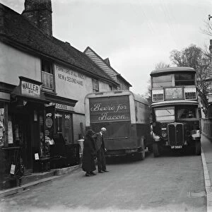 A butcher van and the number 21 bus squeeze past each other in the tight Farningham