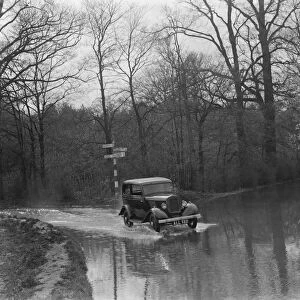 A car drives through the floods in Hockenden, Kent. 1937