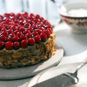 Celebration cream cake toppped with fresh raspberries and with toasted flaked almonds