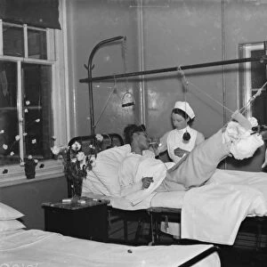 Christmas at the County Hospital in Dartford, Kent. A nurse is helping a patient smoke