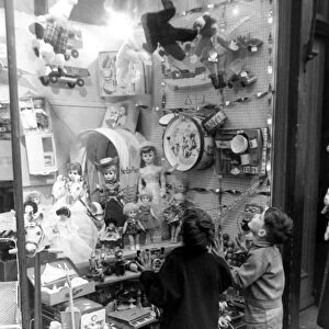A couple of children look longingly at the wonderful toys on display in their local