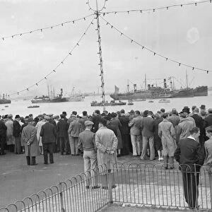 Crowds look at the collection of water vessels on the Thames which are part of the