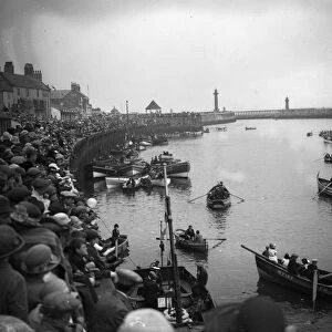 Crowds at Whitby harbour watching the rowing boats on the River Esk, Yorkshire