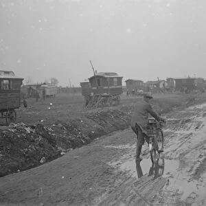 A cyclist negotiates a very muddy road with gypsy caravans parked on Belvedere marshes