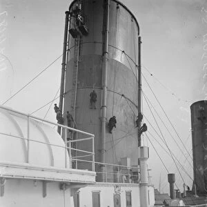 Dry docking the Majestic at Southampton. Men chipping one of the funnels. 17