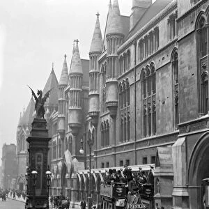 Edwardian London. An open topped, horsedrawn omnibus goes past the Temple Bar
