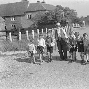 Evacuated children in Wye, Kent, walking down a country road. 1939 / 40