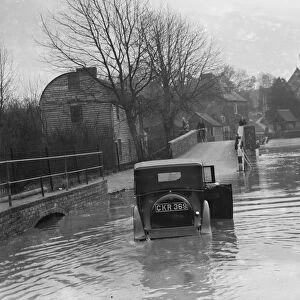 Flooding in Eynsford, Kent. Motorist tries to navigate through the flooded street