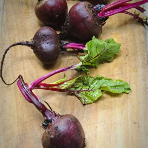 Whole fresh raw beetroots on wooden board credit: Marie-Louise Avery / thePictureKitchen