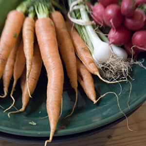 Fresh vegetables from farmers market on dark green platter credit: Marie-Louise