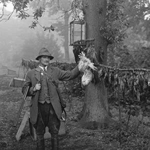 Gamekeeper, Mr Barrett, poses with a hawk he has killed. 1936