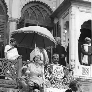 H. M. Queen Elizabeth II rides on an elephant through the streets of Benares, leaving
