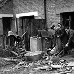 Home front 1940 A bus driver cleans debris from an air raid up before reporting