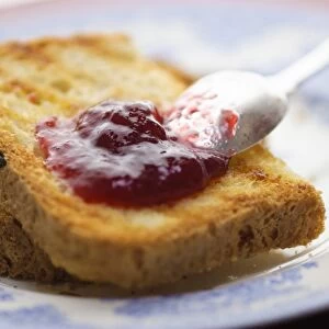 Home made jam on toast made from gluten free bread with silver spoon