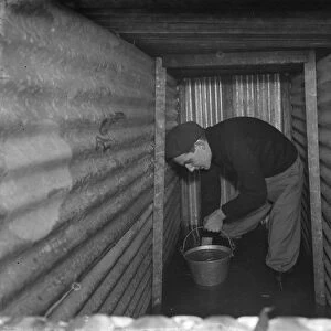 The interior of a flooded dug out in Sidcup, Kent. Mr George Harris attempts