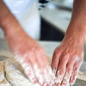 Kneading pizza dough on stainless steel surface. credit: Marie-Louise Avery / thePictureKitchen
