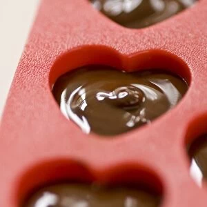 Making heart shaped in chocolates for Valentines day in red heart shaped mould credit