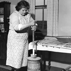 Miss Peggy Macleod making butter using the plunger in Daliburgh South Uist Outer