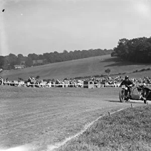 Motorcycling races at Brands Hatch. Two of the side car bikes jostle for position