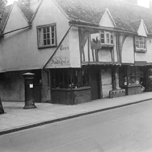 The old cock house shop at Eton, showing the old stocks and pillar box of years ago