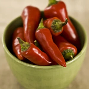 Red hot chilli peppers in green bowl credit: Marie-Louise Avery / thePictureKitchen