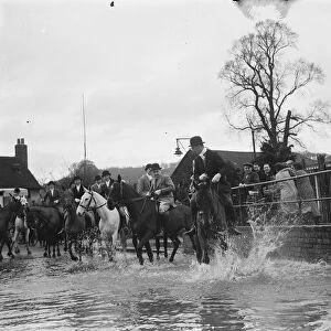 The Royal Artillery Drag Hunt cross a flooded street in Eynsford, Kent