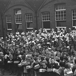 School children at Sidcup Hill School, Kent, wave the boxes containing their coronation
