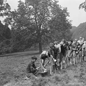 Scouts at Bexley scouts camp. The scouts line up to get a drink. 1937