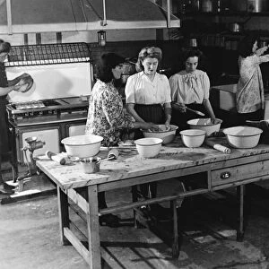 Teaching young women cooking in a kitchen 1950s
